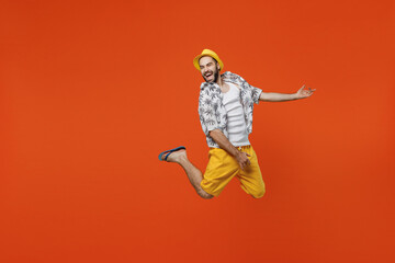 Obraz premium Full body excited fun musician singer young tourist man wear beach shirt hat do playing guitar gesture isolated on plain orange background studio portrait. Summer vacation sea rest sun tan concept
