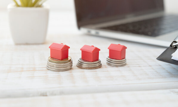 Houses resting on pound coin stacks, Home mortgage concept
