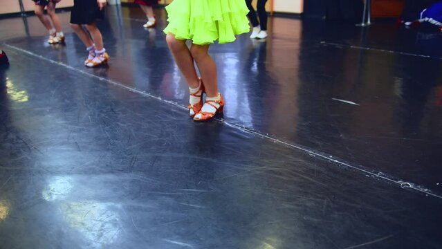 Close-up feet of Caucasian girl in beige high-heels making ballet step in slow motion. Unrecognizable children rehearsing learning dancing in dance studio indoors. Skill and art concept