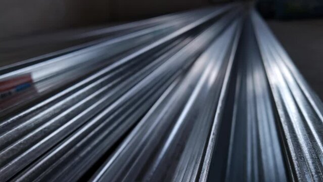 Metal profiles. Stack of stainless steel pipes in warehouse. Rolled metal products. Economic Metals list prices index. Financial crisis. Wall building parts.