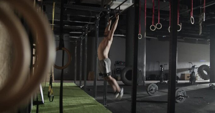 Male athlete doing pull ups in gym