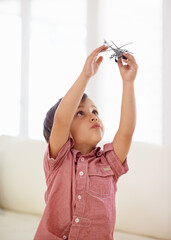 Letting his imagination take flight. A little boy playing with a toy helicopter.