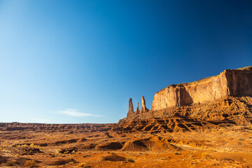 Classic southwest desert landscape under a blue sky and bright sun in Monument Valley in Arizona and Utah.