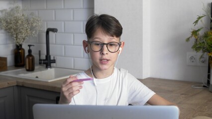 A boy with glasses and headphones in an online lesson. Distance education. Study