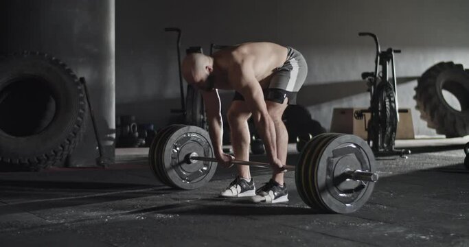 Furious sportsman doing deadlift attempt in gym
