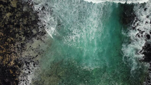 Aerial view Caleta del Mojon Blanco beach, black volcanic stones, bay with turquoise Atlantic Ocean directly above view background. No people. Lanzarote, Canary Islands, Spain
