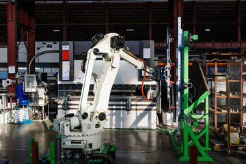 Robotic arm working with metal sheet at hydraulic bending machine - obrazy, fototapety, plakaty