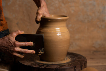 Fototapeta na wymiar Vasos de barro, nas mãos do oleiro, mão masculina 