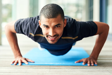 Fototapeta premium If you believe you can, then you will. Portrait of a sporty young man doing pushups outside.