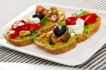 Sandwich with vegetables, walnut and feta cheese at plate on table