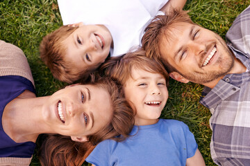 Love makes a family. Portrait of a loving family lying on the grass together.