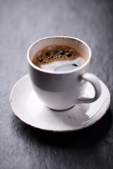 Cup of coffee on dark stone background. Close up. 