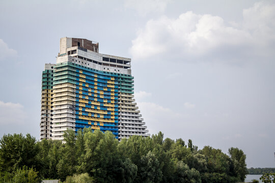 DNIPRO, UKRAINE - AUGUST 15, 2015: Giant coat of arms of ukraine with Tryzub, the Ukrainain trident, on Hotel Parus building. Hotel Parus is an unfinished Soviet building construction. ....
