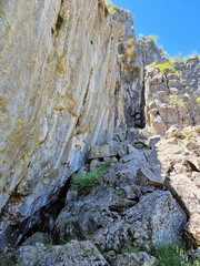 Rocky cliff face with fallen boulders at the base