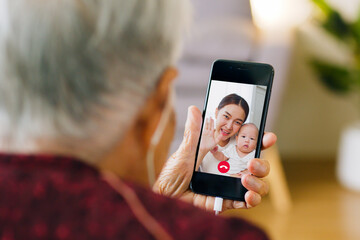 Asian old senior making video call via mobile phone talking with family - obrazy, fototapety, plakaty