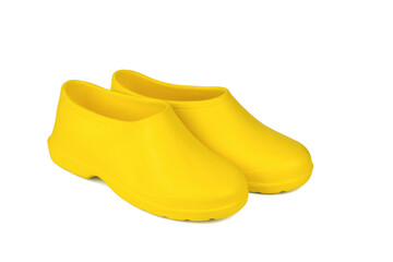 A pair of yellow rubber shoes for rainy weather isolated on a white background.