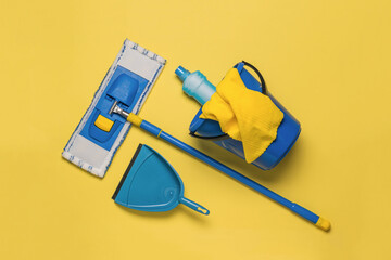 Yellow-blue cleaning kit on a bright yellow background. The concept of maintaining cleanliness....
