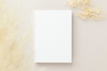 White book blank cover mockup on a beige background, flat lay, mockup