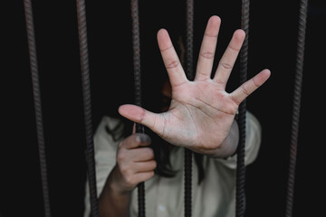 Hopeless person showing stop hand in the cage, Human trafficking concept