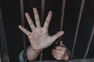 Hopeless person showing stop hand in the cage, Human trafficking concept