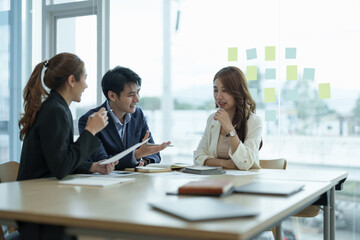 Asian business workgroup designers team with asian woman leader discuss paperwork financial report...