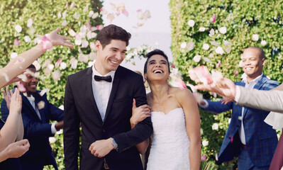 And they get to be happy in the end. Cropped shot of an affectionate young newlywed couple leaving their wedding venue with their guests throwing confetti in the background.