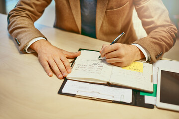 Writing it down so he doesnt forget. High angle shot of an unrecognizable male designer working at his desk in the office.