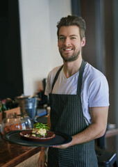 Service with a smile. Cropped portrait of a young waiter taking an order to a customer.