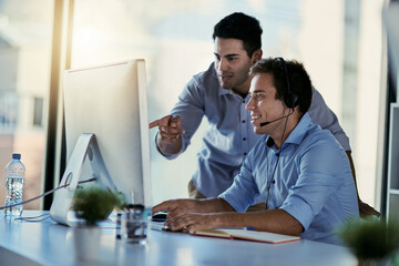 Getting the training he needs to deliver a quality service. Cropped shot of two call centre agents...