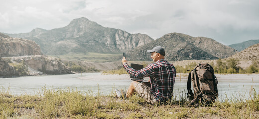 men using mobile phone on the beach of river