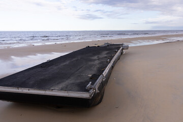Flood damaged pontoon on beach