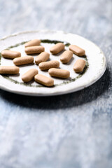 Ashwagandha (Withania somnifera) tablets. Wooden background. Soft focus. Close up. Copy space.