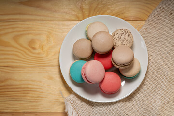 Close up macaron dessert pastel tones on white plate , Sweet and colorful french macaroons  on wooden background, Dessert.