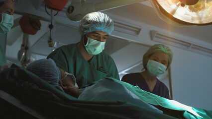 Futuristic operating room simulation - a surgeon diagnosing a senior woman's heart problem via a...