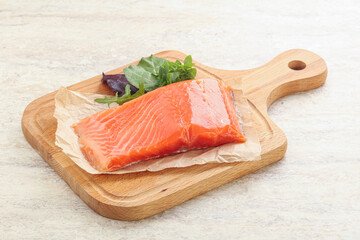 Raw salmon fillet over board