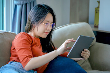 Young woman happily playing with tablet. Concept, life, happiness and modern technology.