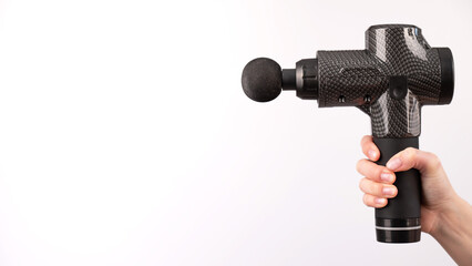 Close-up of a female hand with a portable massager gun on a white background. 