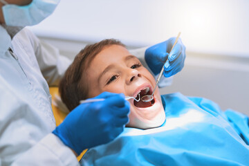 Im going to have a bright smile after this. Shot of a young little boy lying down on a dentist chair while getting a checkup from the dentist.