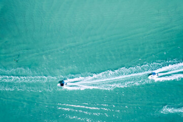 Drone view of sea with crystal clear blue water. Attractive men swimming on sea.