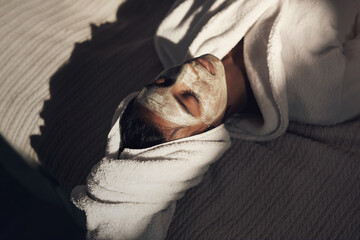 Time that soothes the soul is time worth spending. Shot of a young woman giving herself a facial at...