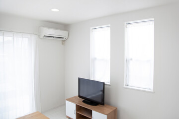 white living room with  air conditioner on wall.