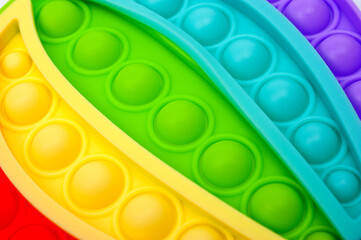 Rainbow colored bubble toy in the form of a balloon to relieve stress.