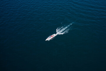 Boat performance drone view. Performance speedboat moving fast on blue water aerial view. Big white...