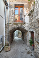 Fototapeta na wymiar A narrow street among the old stone houses of Taurasi, town in Avellino province, Italy.