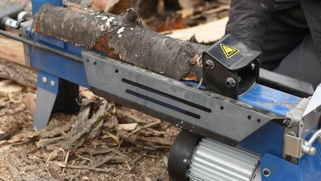 Hydraulic wood splitter splits wormwood. Firewood production.
