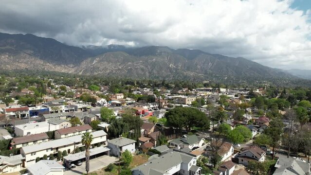 An idyllic suburban community against the picturesque mountains on a spring day - aerial flyover