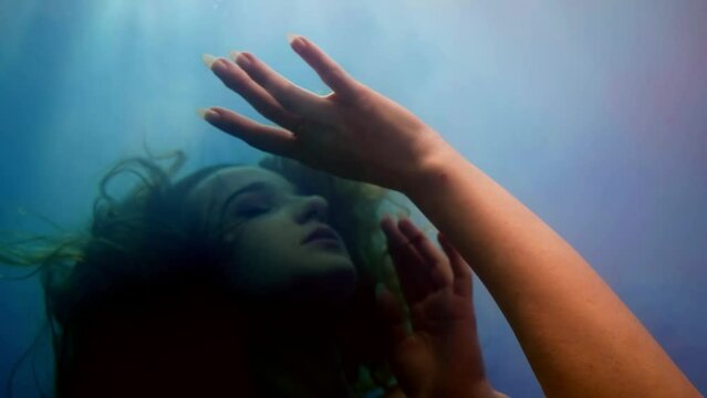 lady in deep, underwater portrait of pretty woman with swaying hair in water, dive and drown