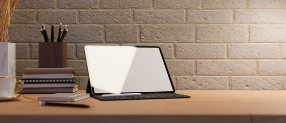 Portable digital tablet mockup on table against white brick wall.