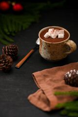 Hot dark chocolate milk with marshmallow on black table