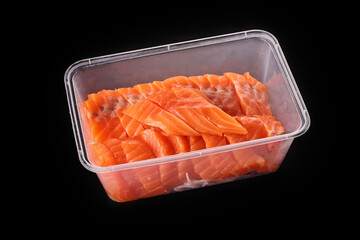 salmon sashimi (raw) sliced stacked in a plastic food container isolated on black background.